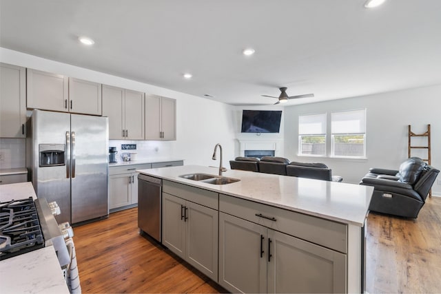 kitchen featuring gray cabinetry, sink, hardwood / wood-style flooring, appliances with stainless steel finishes, and tasteful backsplash