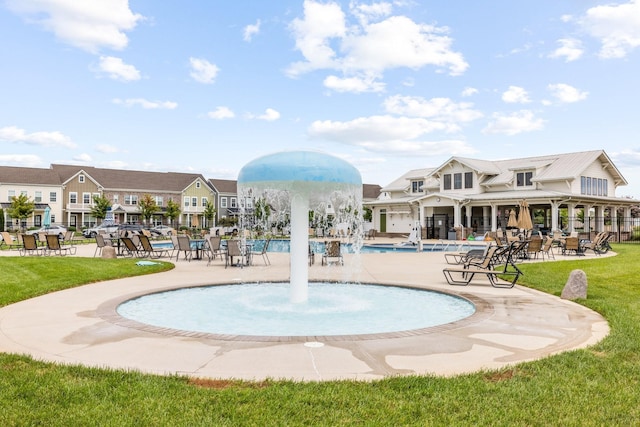 view of swimming pool with a yard, pool water feature, and a patio