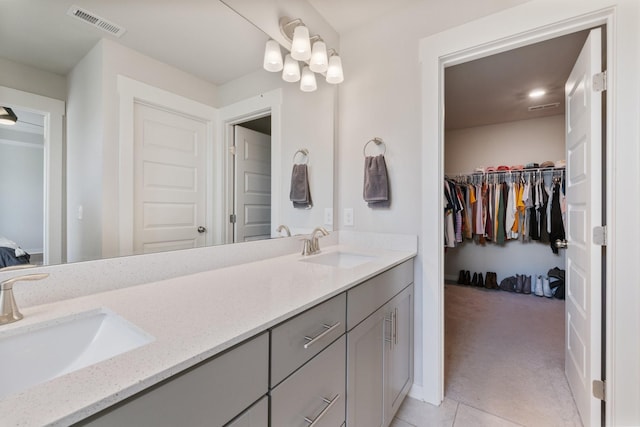 bathroom with vanity, an inviting chandelier, and tile patterned floors