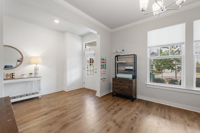 interior space with wood-type flooring, an inviting chandelier, and ornamental molding