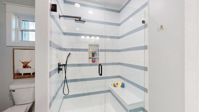 bathroom with a shower with shower door and toilet