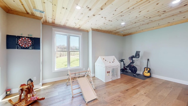 game room with light wood-type flooring, wood ceiling, and crown molding