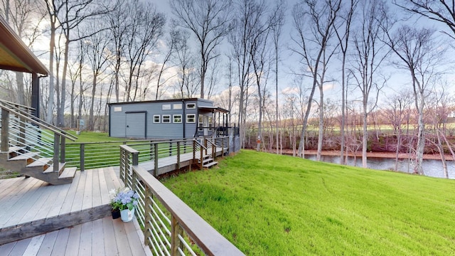 view of yard featuring an outbuilding and a deck with water view