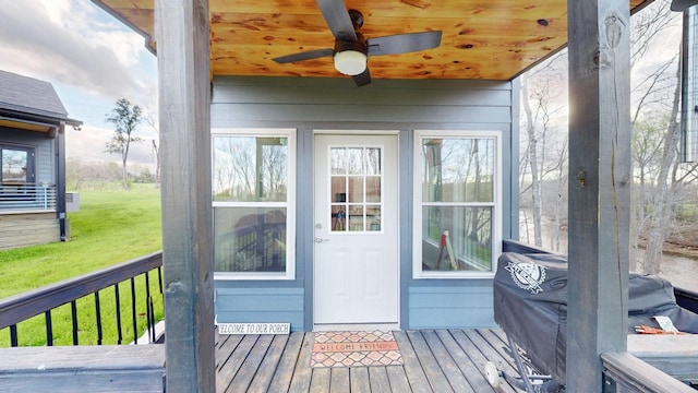 sunroom featuring ceiling fan and wooden ceiling