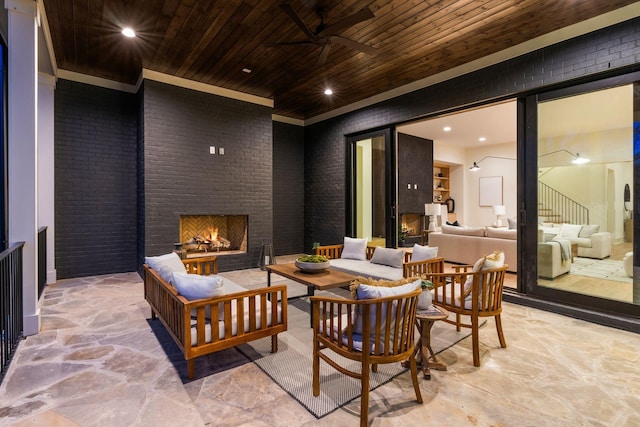 view of patio / terrace with ceiling fan and an outdoor living space with a fireplace