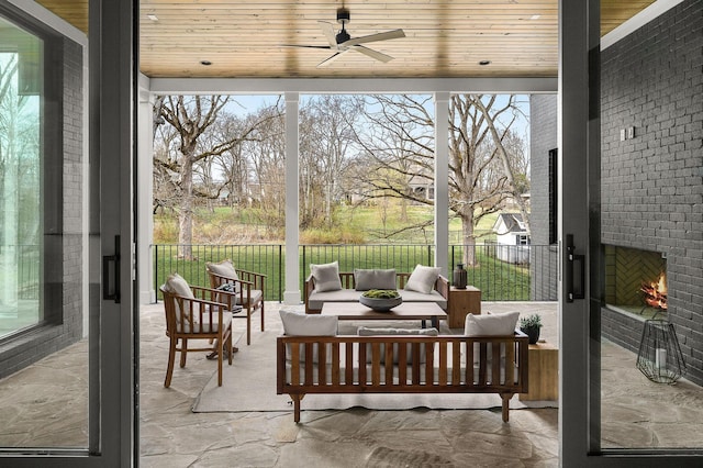 sunroom / solarium featuring ceiling fan, a wealth of natural light, and wooden ceiling