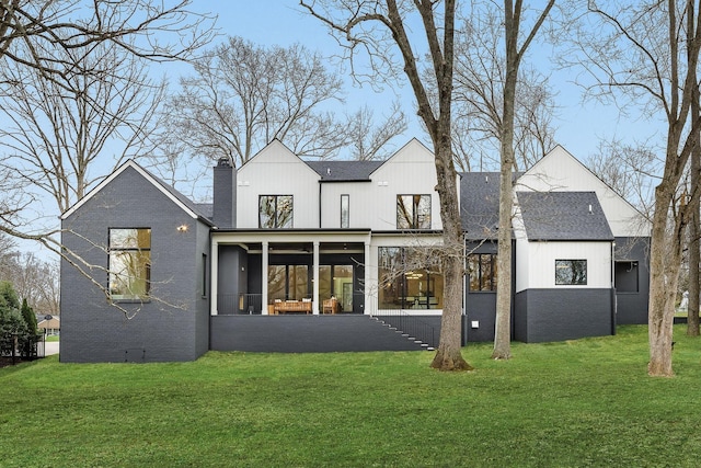 back of property with a lawn and a sunroom