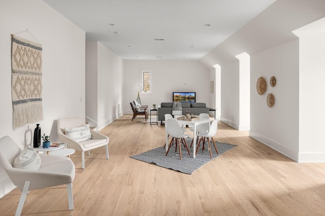 dining space featuring lofted ceiling and light wood-type flooring