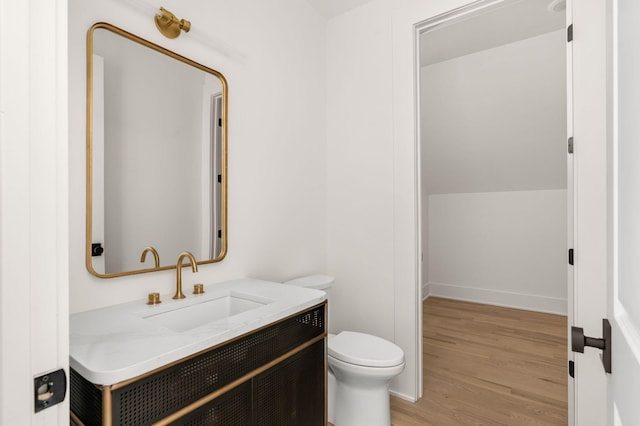 bathroom with hardwood / wood-style flooring, vanity, and toilet