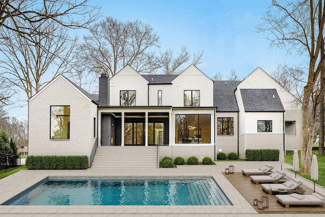 rear view of property featuring a sunroom and a patio area