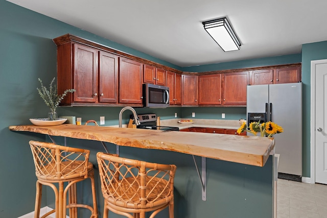 kitchen featuring a breakfast bar, kitchen peninsula, and stainless steel appliances