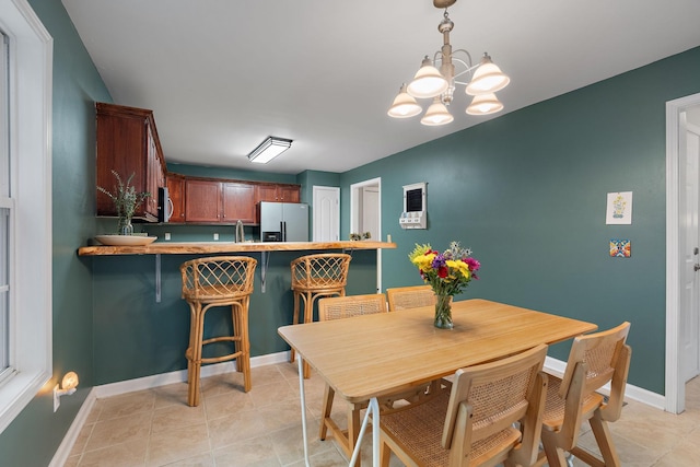 tiled dining room featuring a notable chandelier