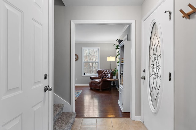 tiled foyer featuring ornamental molding