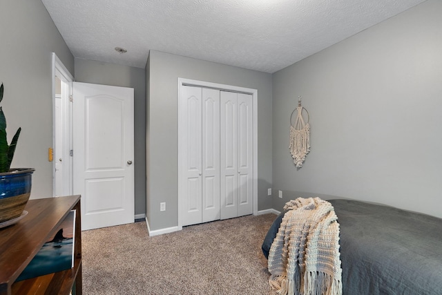 carpeted bedroom with a textured ceiling and a closet