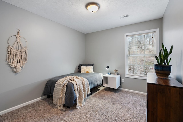 carpeted bedroom featuring a textured ceiling