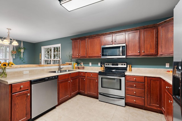 kitchen featuring kitchen peninsula, sink, hanging light fixtures, and appliances with stainless steel finishes