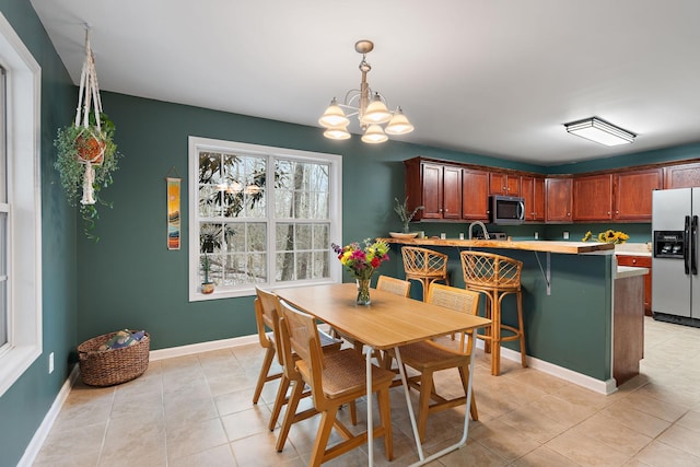 tiled dining room featuring an inviting chandelier