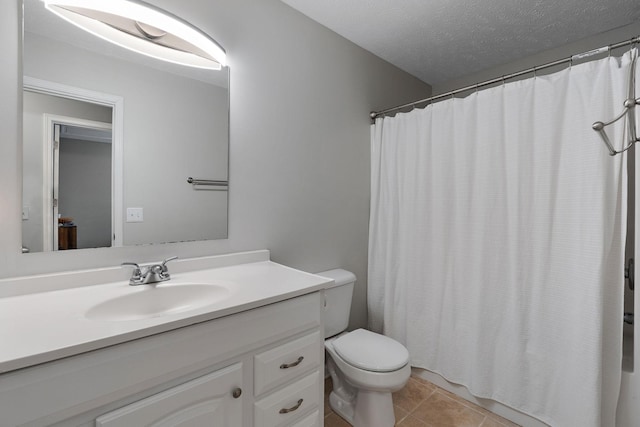 bathroom with vanity, tile patterned floors, toilet, a textured ceiling, and walk in shower