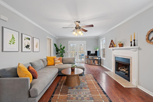 living room with a tiled fireplace, ceiling fan, dark hardwood / wood-style floors, and ornamental molding