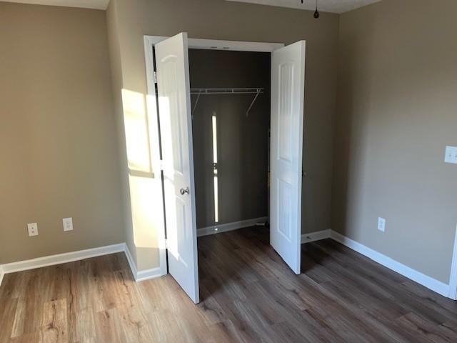 unfurnished bedroom featuring a closet and hardwood / wood-style floors