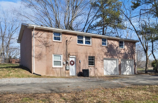 back of house with a garage and central AC