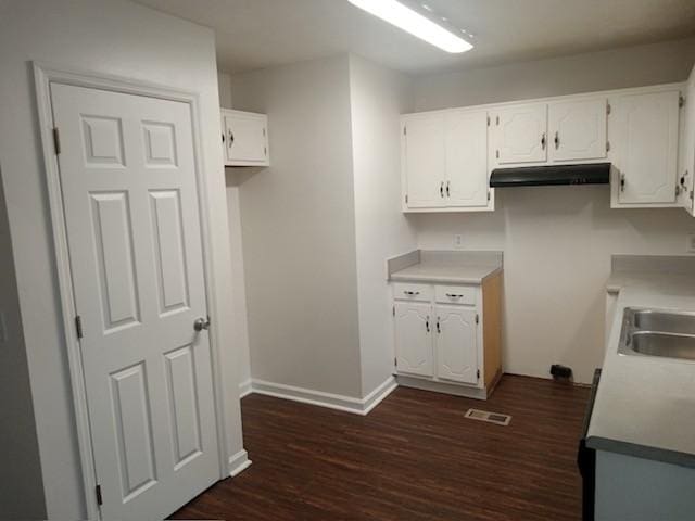 kitchen featuring white cabinets, dark wood-type flooring, and sink