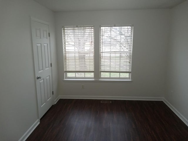 unfurnished room featuring dark wood-type flooring