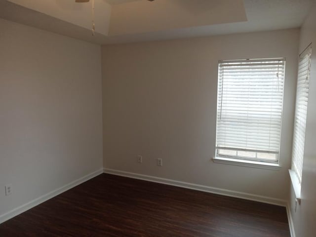 spare room with a wealth of natural light, dark hardwood / wood-style flooring, and ceiling fan