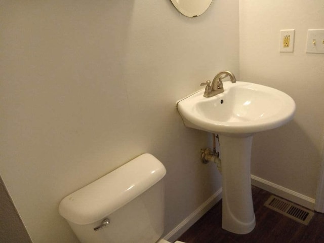 bathroom with wood-type flooring and toilet