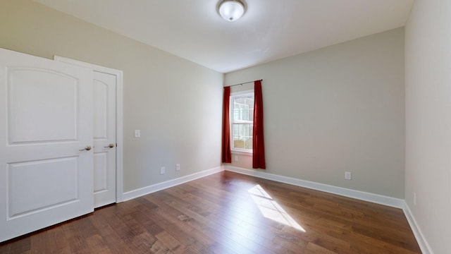 unfurnished room featuring dark wood-type flooring