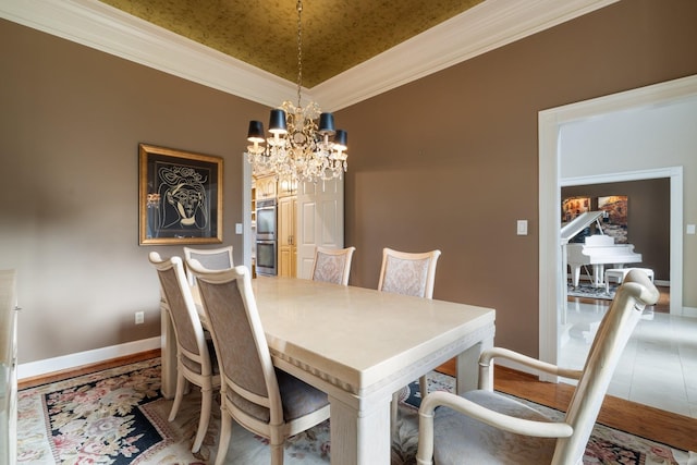 dining room with a notable chandelier, lofted ceiling, and crown molding