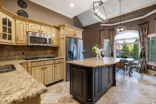 kitchen with an inviting chandelier, decorative backsplash, ornamental molding, appliances with stainless steel finishes, and a kitchen island