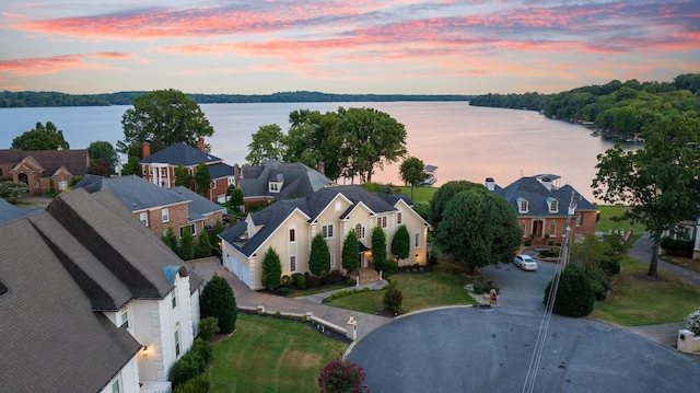 aerial view at dusk featuring a water view