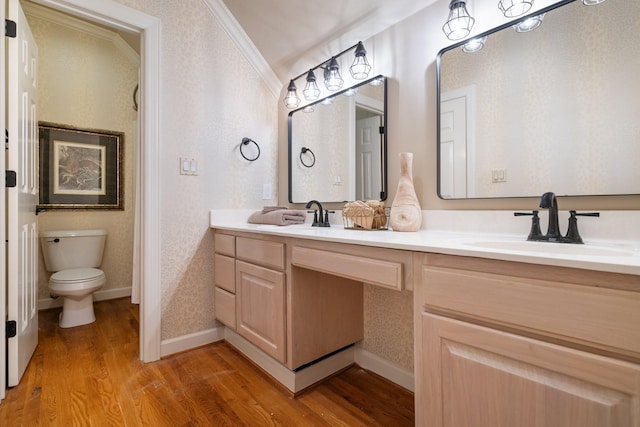 bathroom with hardwood / wood-style flooring, vanity, toilet, and ornamental molding