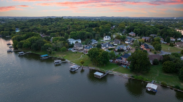 aerial view at dusk featuring a water view