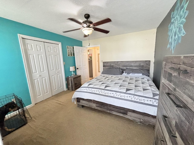 bedroom featuring ceiling fan, a closet, carpet, and a textured ceiling