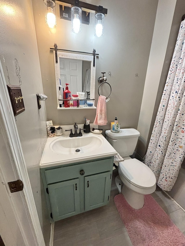 bathroom featuring hardwood / wood-style flooring, vanity, toilet, and walk in shower