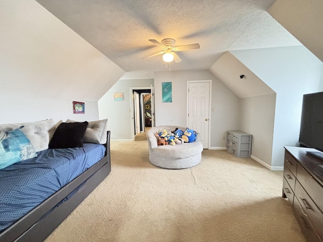 bedroom featuring light carpet, a textured ceiling, vaulted ceiling, and ceiling fan