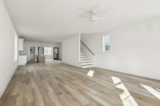 unfurnished living room featuring ceiling fan and light hardwood / wood-style floors