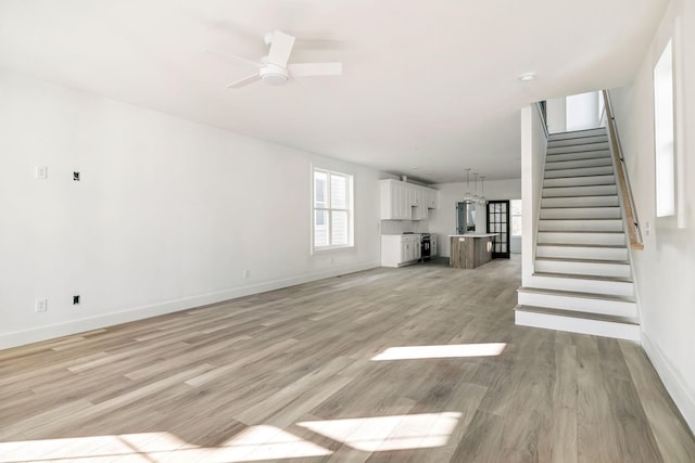 unfurnished living room with ceiling fan and light wood-type flooring