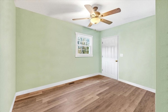 empty room with ceiling fan and light wood-type flooring