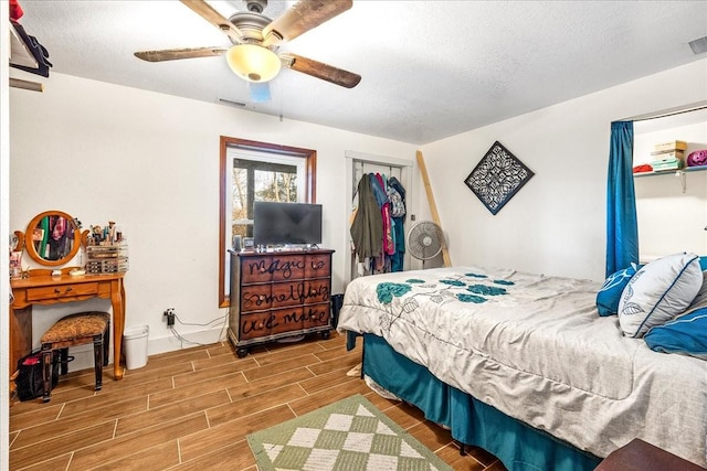 bedroom with ceiling fan, a textured ceiling, and a closet