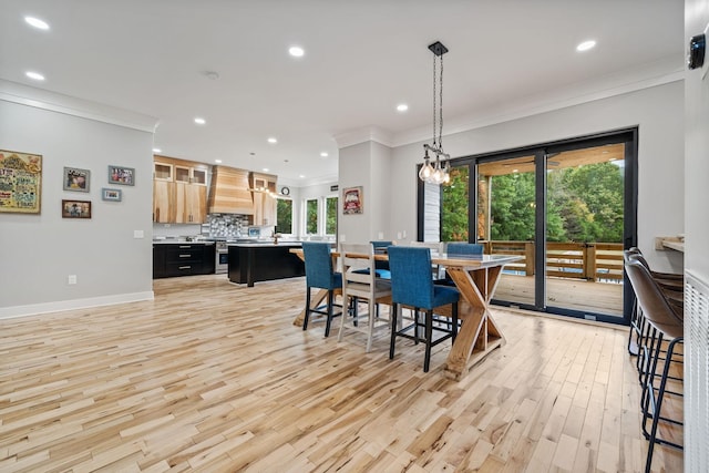 dining room featuring light wood-type flooring and ornamental molding