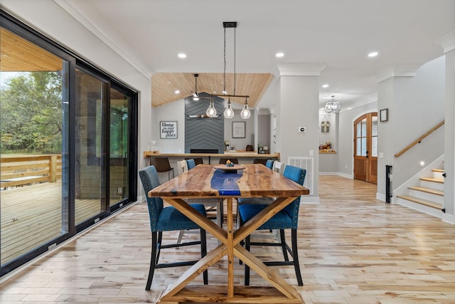 dining space featuring a wealth of natural light, crown molding, light hardwood / wood-style floors, and lofted ceiling