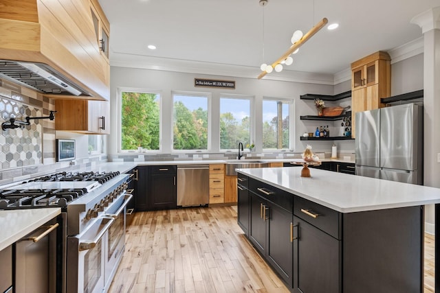 kitchen with sink, stainless steel appliances, decorative backsplash, a kitchen island, and custom range hood