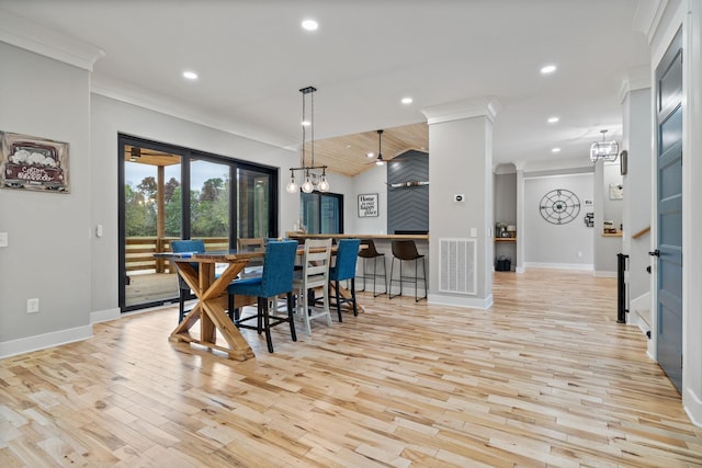 dining space featuring crown molding, light hardwood / wood-style flooring, and a notable chandelier