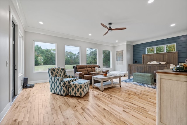 living room with crown molding, ceiling fan, and light wood-type flooring