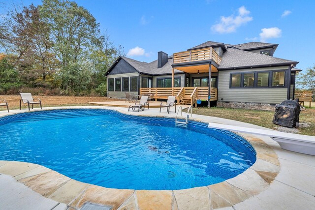 view of pool with a diving board, a deck, and a patio