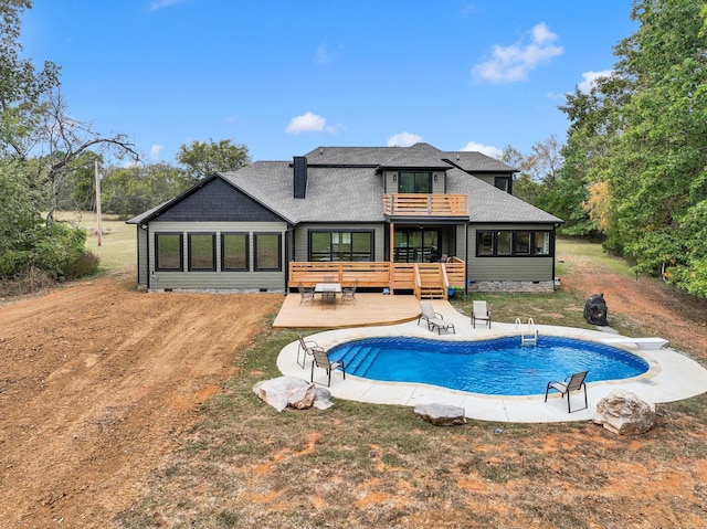 back of property featuring a swimming pool side deck and a balcony