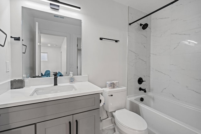 full bathroom with vanity, tiled shower / bath combo, and toilet